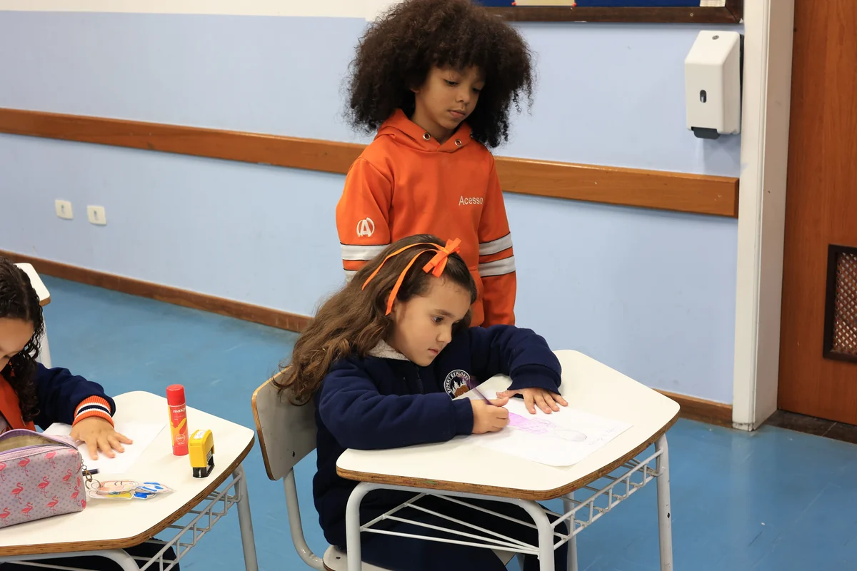 Crianças do Colégio Acesso desenhando juntas em sala de aula